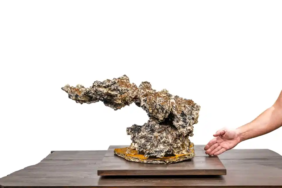 Vertikalrock in Gesamtansicht mit auskragendem Felsvorsprung und einer Hand rechts daneben