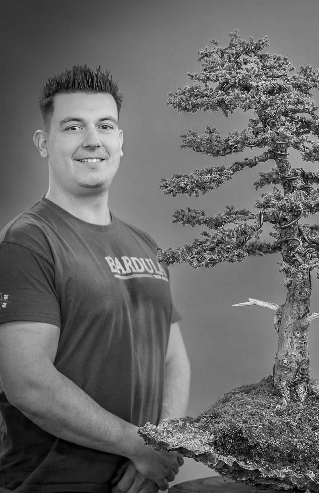Yannick Kiggen, belgischer Bonsai-Künstler und Gründer von Yama Bonsai, präsentiert einen kunstvoll gestalteten Bonsai im Rahmen eines Workshops oder einer Demonstration.